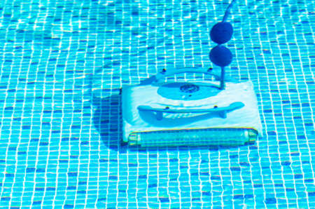 Cleaning the pool bottom with an underwater vacuum cleaner.の写真素材