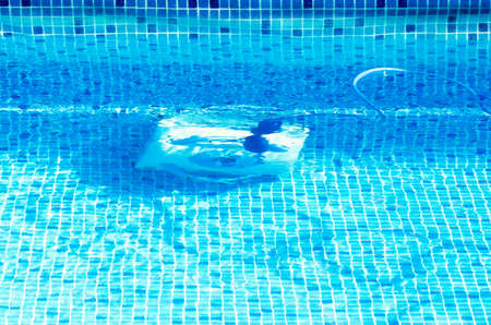 Cleaning the pool bottom with an underwater vacuum cleaner.の写真素材