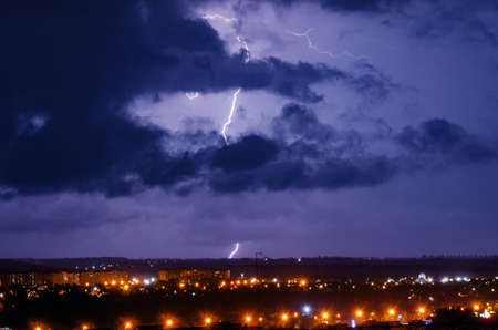Thunderstorm with lightning and thunder over the night city.の写真素材