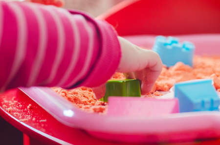 The hands of a child playing with kinetic sand.の写真素材