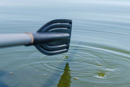 A paddle attached to a rubber inflatable boat rowing on a lake.の写真素材