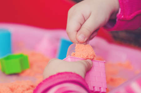 The hands of a child playing with kinetic sand.の写真素材