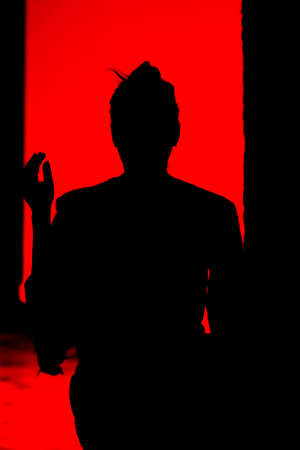 Black silhouette of a girl on a red background.の写真素材