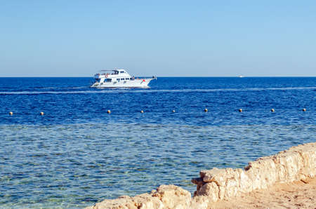 Pleasure tourist boat with passengers sailing in the clear blue water of the Red Sea