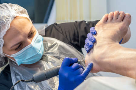 Hardware pedicure, sanding the foot with an abrasive disc.