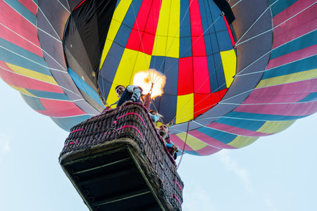 Belaya Tserkov, Ukraine, August 24, 2020 colorful hot air balloon with tourists in a basket rises to the blue sky.のeditorial素材