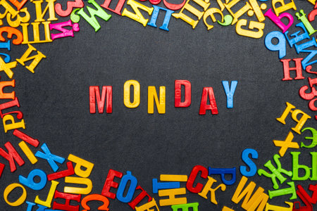 Monday word made of bright colored letters on black background.の写真素材