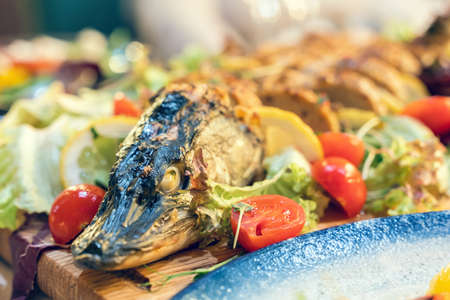 Stuffed pike decorated with vegetables and fruits with the greens.の写真素材