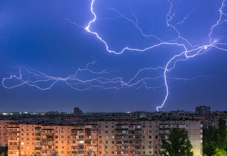 Thunderstorm with lightning above the night city.の写真素材