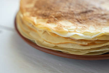 Crepes, thin pancakes on a plate on a white wooden table.の写真素材