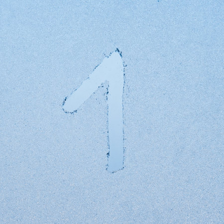 Number 1, written on glass with frost in the frost in winter, close up.の写真素材