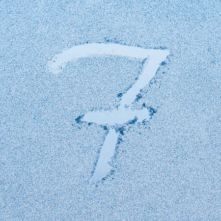 Number 7, written on glass with frost in the frost in winter, close up.の写真素材