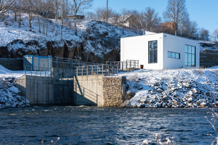 A small hydroelectric power station is located on the river in winter.の写真素材