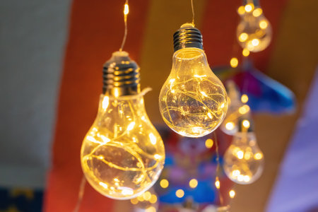 Decorative incandescent lamp with garland lights, background.