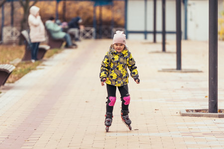 Cute little girl learning to roller skate.の写真素材