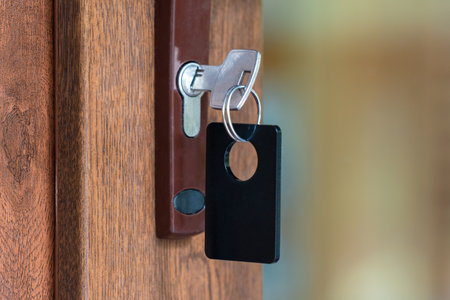 Key with key fob in the keyhole of a closed door.