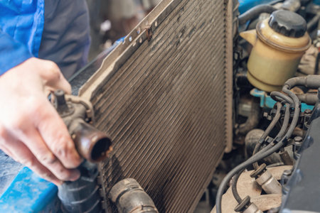 A man removes an old broken radiator from a car.の写真素材