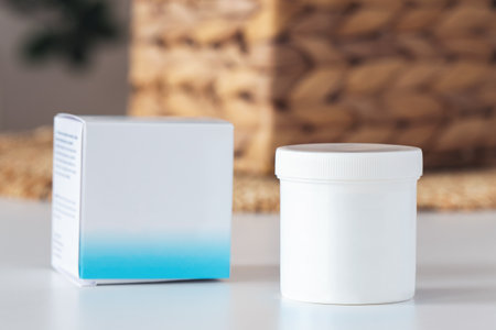 White plastic jar with cream and box, cosmetic product.