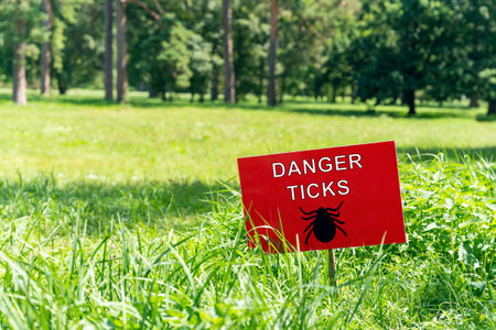 Sign on the law with the inscription: danger ticks.の写真素材