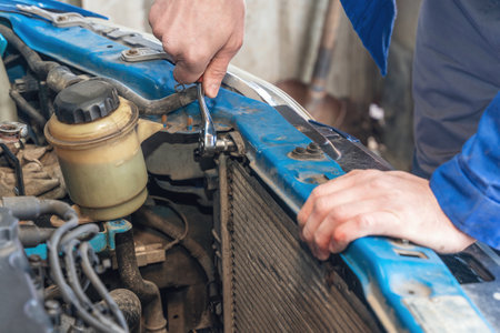 A man replaces an old broken radiator in a car with a new one.の写真素材