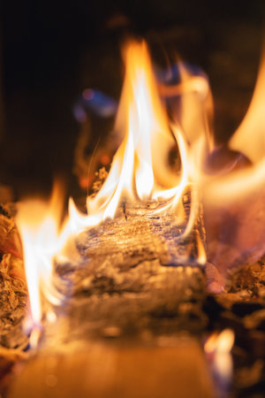 Bright flame of a burning fire in the dark.