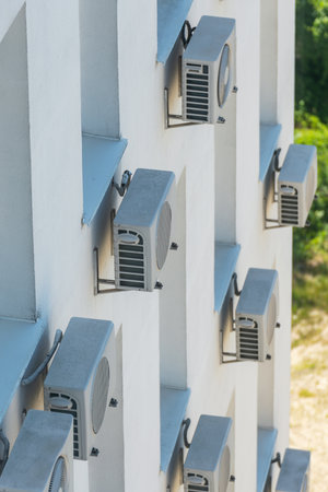 Facade of an office building with many air conditioners on the windows.の写真素材