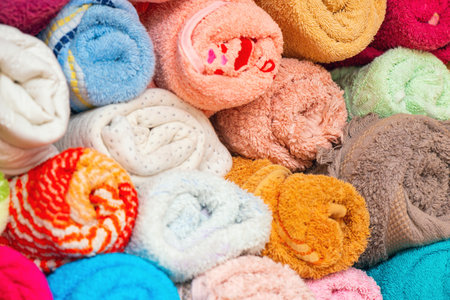 Multicolored towels rolled into rolls in a linen closet.の写真素材
