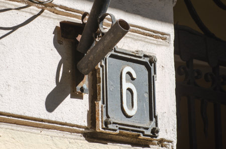 Old weathered square metal house number sign with number 6 close up.の写真素材