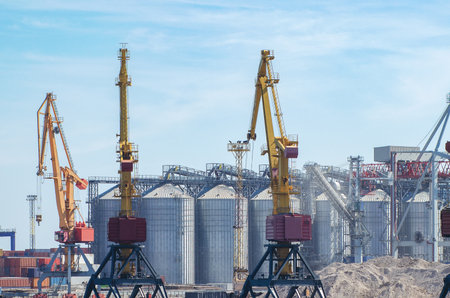 Lifting harbor cranes, shipping containers and granaries in the cargo seaport.の写真素材