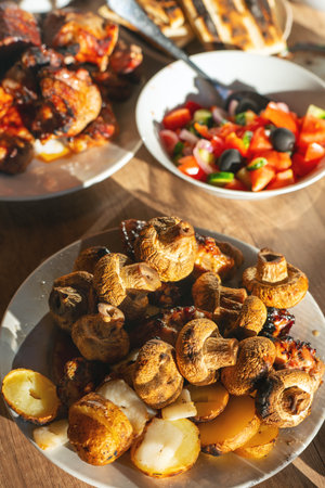 Pork shashlik, champignons, potatoes with lard fried on the grill in a plate on the table.の写真素材