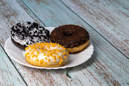 Donuts on a white plate on a wooden tableの写真素材