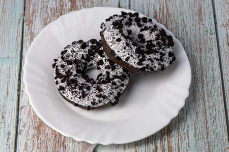 Donuts on a white plate on a wooden tableの写真素材