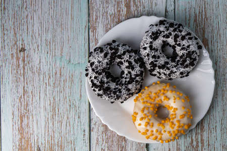 Donuts on a white plate on a wooden tableの写真素材