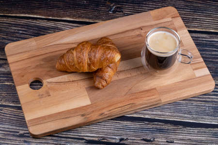 Croissants with a cup of coffee on a wooden board.の写真素材