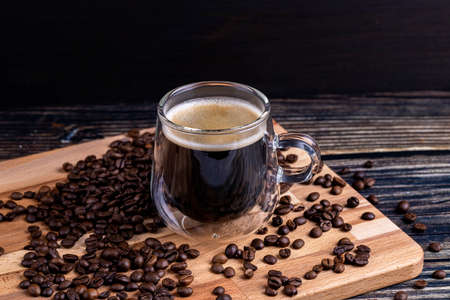 Coffee mug on wooden board and coffee beansの写真素材