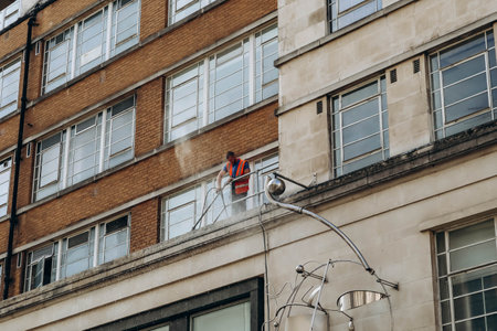 London, United Kingdom - September 25, 2023: A man cleaning facades with water pressure in central Londonのeditorial素材