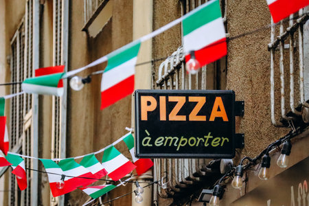 Pizzeria sign with Italian flags (exact translation from French - "Pizza to go")のeditorial素材