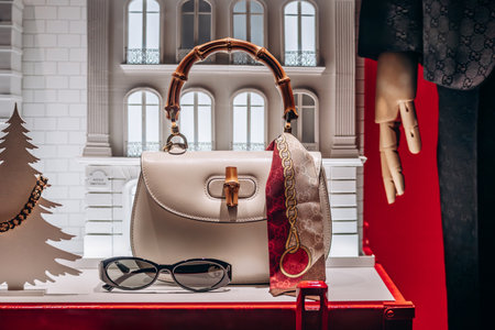 Cannes, France - 10 November 2024: The iconic Gucci Bamboo bag, silk scarf, and sunglasses displayed in a boutique window on the Croisette promenade in Cannesのeditorial素材