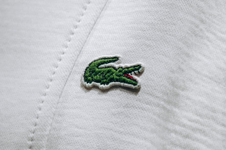 Bologna, Italy - October 6, 2024: A close-up of the famous crocodile embroidery on a Lacoste polo shirtのeditorial素材