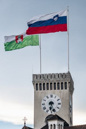 Flag of Slovenia and City of Ljubljana waving over the Ljubljana castle towerの写真素材