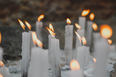 Close-up of lit white candles, partially out of focusの写真素材