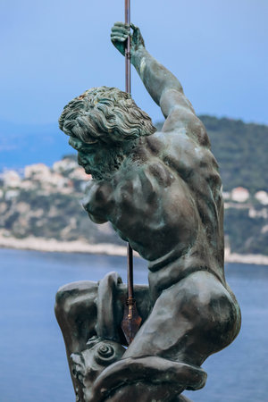 Saint Jean Cap Ferrat, France - 1 June 2023: Poseidon statue aside the Lighthouse of Cap Ferrat