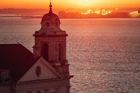 Silhouette of Saint Stephen Church in Lisbon with a view of the Tagus River at sunset