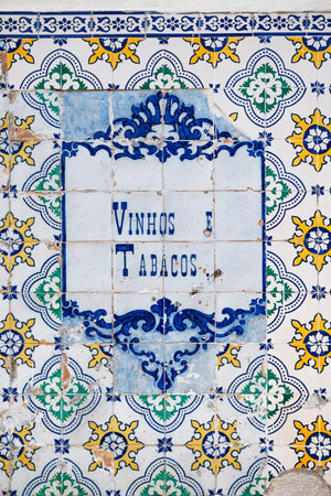 Traditional azulejo facade in Lisbon with the inscription "Vinhos e Tabacos" (Wine and Tobacco)の写真素材