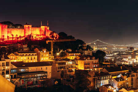 A beautiful nighttime panoramic view of Lisbon from a hilltop viewpoint, showcasing the illuminated cityscapeの写真素材