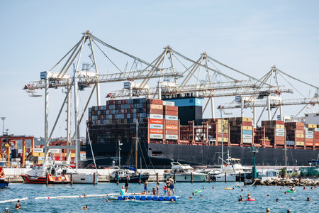 Koper, Slovenia - August 16, 2024: View of the Port of Koper with people swimming nearby along the...