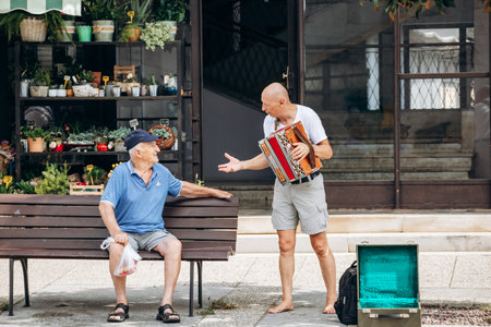 Koper, Slovenia - August 16, 2024: Two people having a conversation at the market square in the...