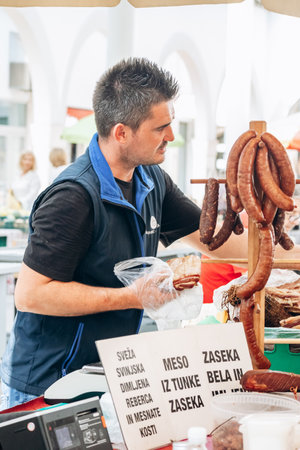 Koper, Slovenia - August 16, 2024: People at the central food market in Koper, browsing stalls and...