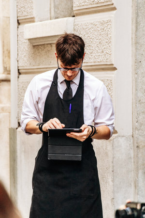Trieste, Italy - August 18, 2024: Waiter at the legendary Caffe San Marco in Trieste, serving guests...