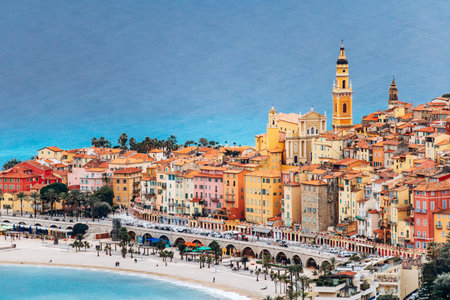 Picturesque view of Menton's city center with colorful historic buildings and the blue sea surrounding the townの写真素材
